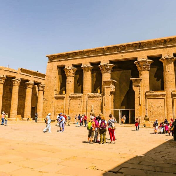 Turistas disfrutando de una excursión frente al Templo de Edfu en Egipto.