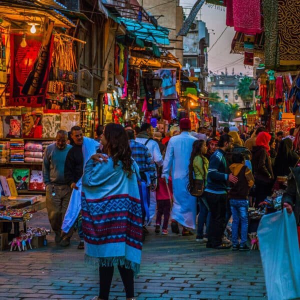 Vista nocturna de la Calle Al Muizz con arquitectura histórica y ambiente vibrante.