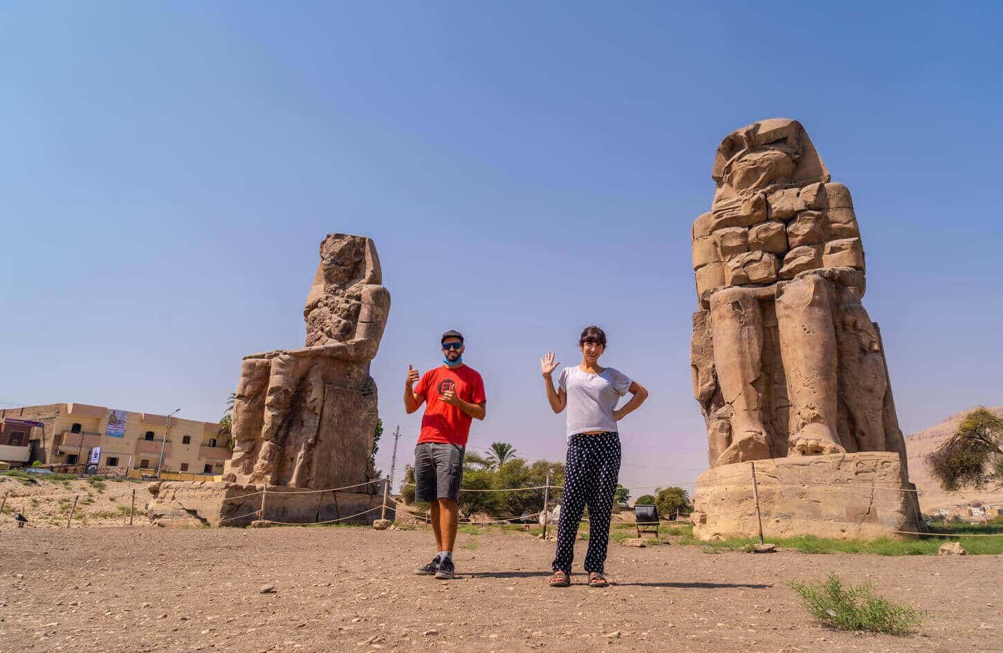 Pareja de turistas junto a las estatuas de Memnon en Luxor, Egipto.