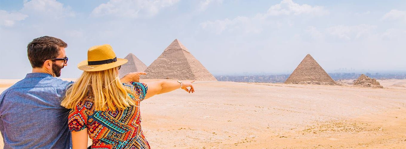 Pareja disfrutando de las Grandes Pirámides de Guiza en Egipto.