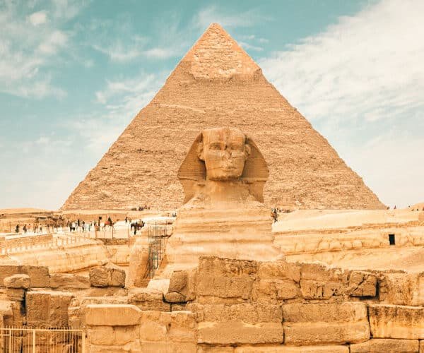 Esfinge gigante con las pirámides de Giza al fondo.