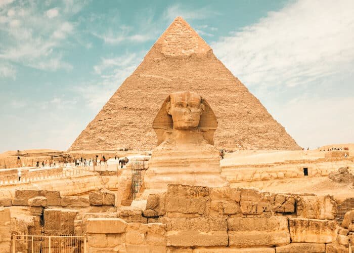 Esfinge gigante con las pirámides de Giza al fondo.