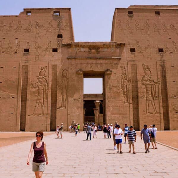 Turistas admirando la impresionante arquitectura del Templo de Edfu en Asuán.