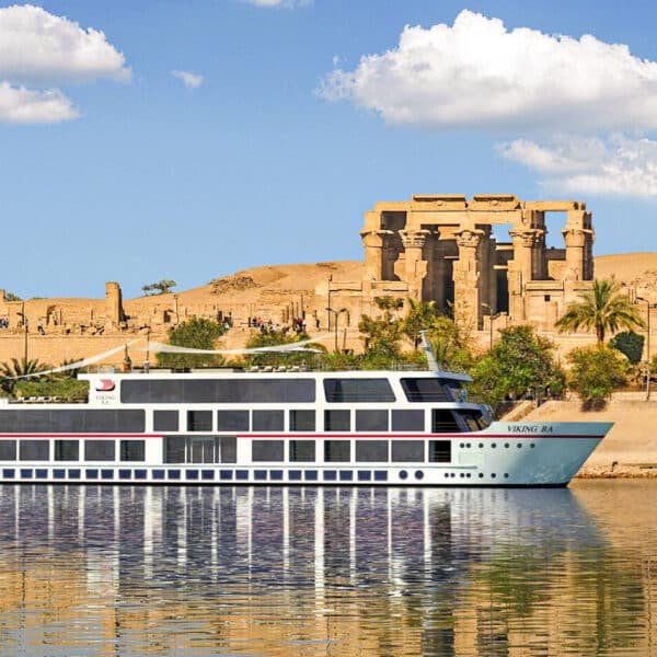 Barco de crucero Viking navegando por el río Nilo junto al templo de Kom Ombo.