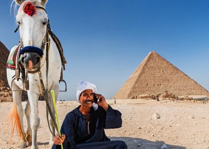 Hombre sentado frente a las pirámides de Egipto.