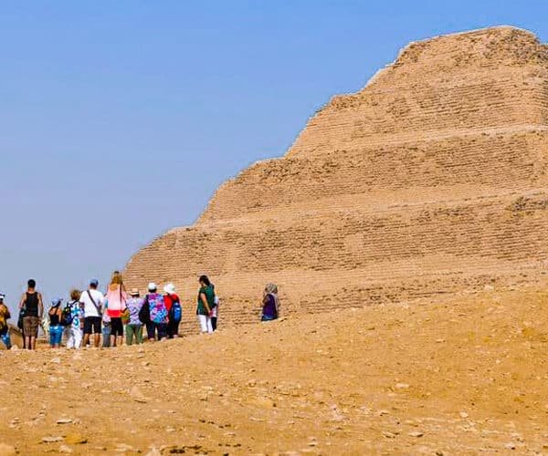 Turistas posando frente a la pirámide de Saqqara en Egipto.
