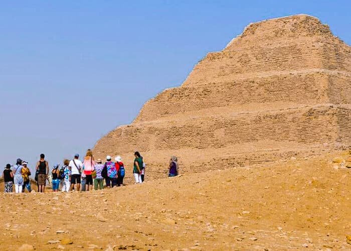 Turistas posando frente a la pirámide de Saqqara en Egipto.