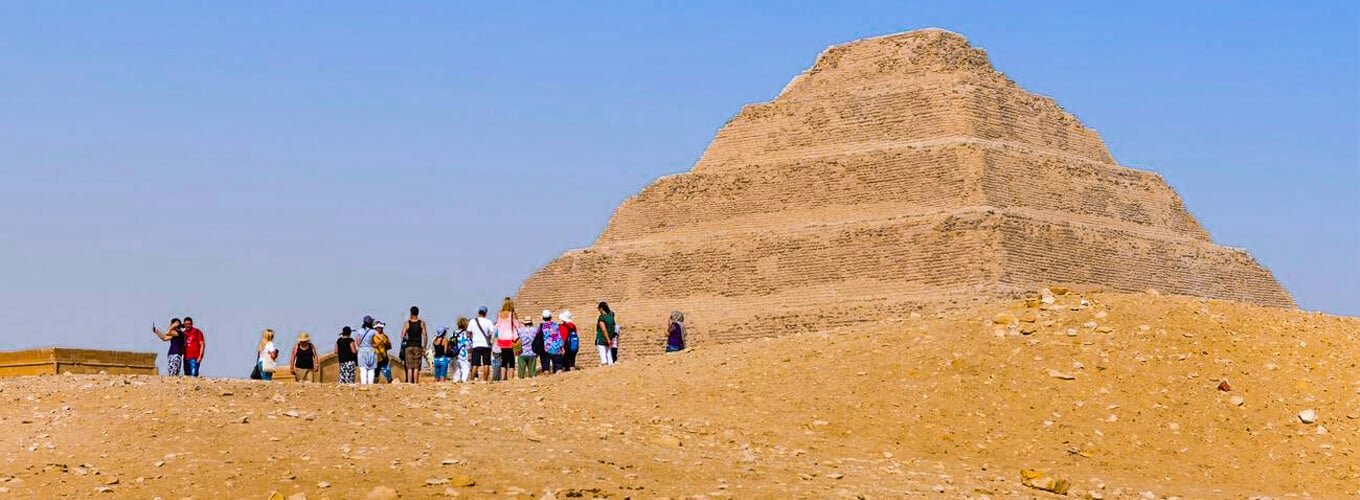 Turistas posando frente a la pirámide de Saqqara en Egipto.