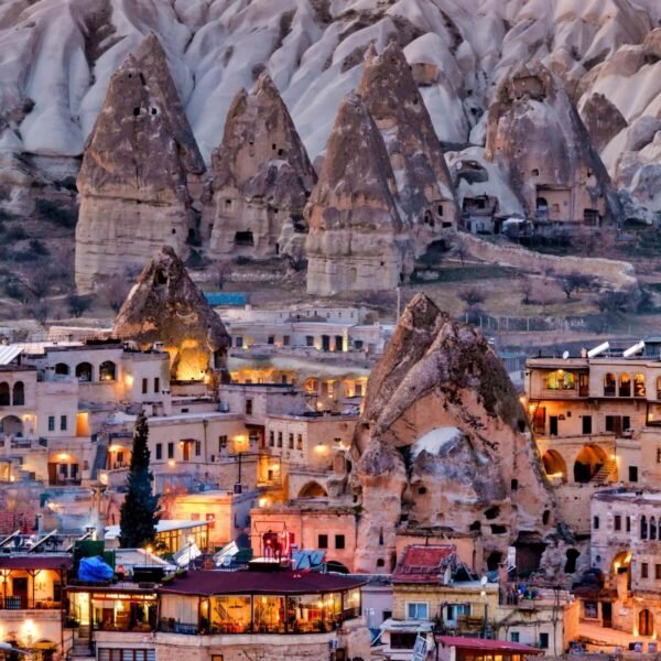 Vista nocturna de la ciudad de Goreme en Turquía con paisajes únicos y arquitectura iluminada.