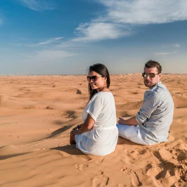 Pareja disfrutando de una emocionante aventura de safari en el desierto de Dubái.