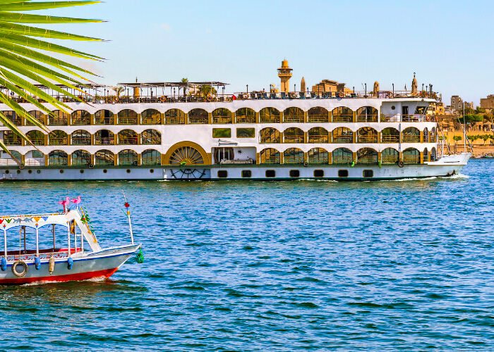 Vista del Nilo y la ciudad de Luxor al atardecer con colores vibrantes.