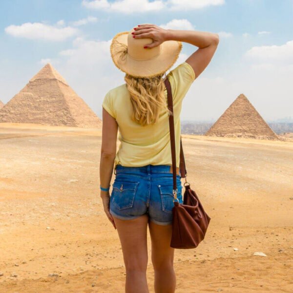 Niña sonriente frente a las pirámides de Egipto.